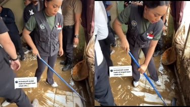 Zita Anjani limpia el barro que queda de las inundaciones en las casas de los residentes